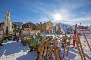 A ski resort with wooden buildings, ski equipment, and a sunlit snowy landscape. - Perla Ski in, Livigno, Italy (Livigno)