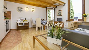 A modern kitchen with a microwave, kettle, and a small dining area with chairs and a table. - Appartamento Villa Lina with Lake View, Riva del Garda, Italy (Riva del Garda)