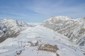 A snow-covered mountain resort with ski lifts, a lodge, and a ski slope.