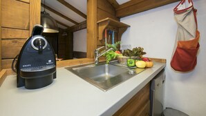 Eine Küche mit integriertem Espressomaschine, Spüle und Holzboden.