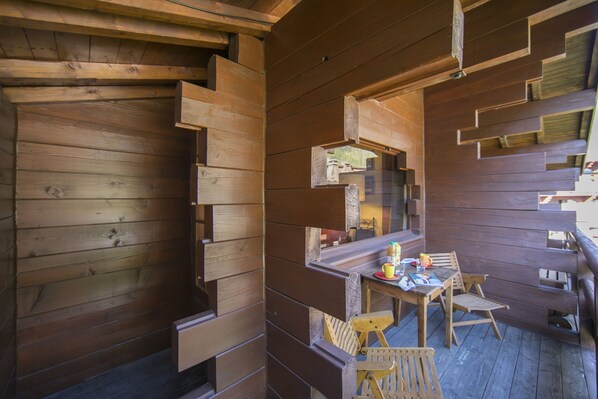 Una cabaña de madera con comedor que incluye una mesa y sillas.
