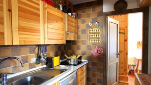 A kitchen with wooden cabinets, a stainless steel sink, and a dish rack. - Vista Livigno, Livigno, Italy (Livigno)