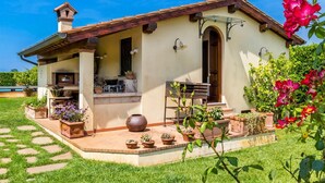 A house with a patio, outdoor seating, and potted plants. - Villa Pallina 4BR Villa with Private Pool, Massarosa, Italy (Massarosa)
