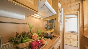Una cucina con mobili in legno, un piano di lavoro in acciaio inox e una selezione di verdure fresche.