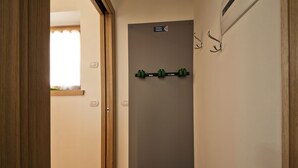 A hallway with a door labeled "VESTATO FUMANE," a window with a curtain, and a wall-mounted hook. - Romantico, Livigno, Italy (Livigno)