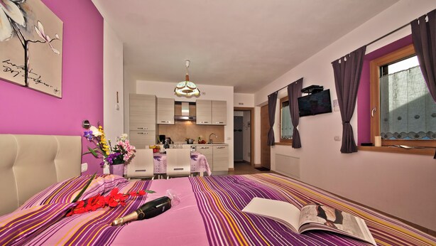 A bedroom with a bed, a bedside table, a nightstand, and a window with curtains. - Romantico, Livigno, Italy (Livigno)
