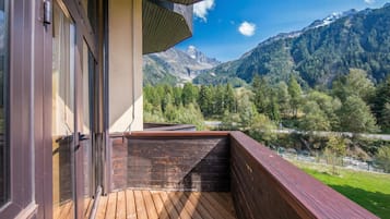 Een houten terras met uitzicht op een bergketen.