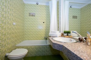 A bathroom with a toilet, bathtub, sink, and mirror. - Twin Home, Lugano, Switzerland (Lugano)