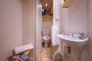 A small bathroom with a toilet, sink, and a towel on a bench. - Grand Roc A220 150m from Slopes, View & Parking, Argentière (Chamonix), France (Argentière (Chamonix))