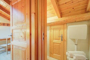 A wooden interior with a door, a toilet, and a sink. - Genziana, Livigno, Italy (Livigno)