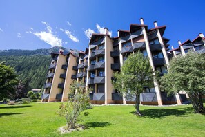A multi-story hotel with balconies, surrounded by greenery and mountains. - Grand Roc B220 260m from Slopes, View, Parking & WiFi, Argentière (Chamonix), France (Argentière (Chamonix))