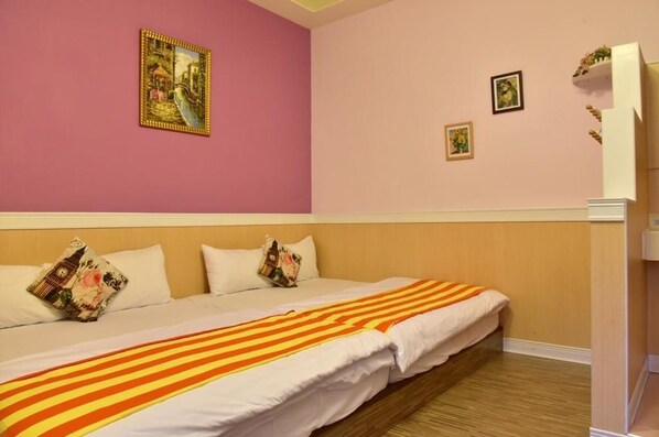 A hotel room with a bed, pillows, and a painting on the wall. - Vitoria's Home (Liuqiu)