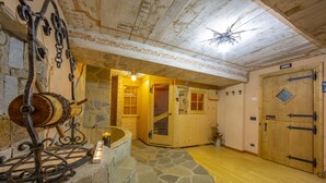 A rustic interior with a stone fireplace, wooden doors, and a stone staircase leading to a wooden door. - Diamante Ski in, Livigno, Italy (Livigno)