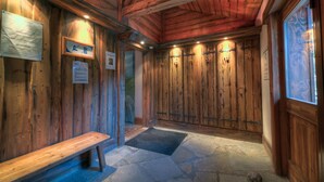 Interior de madera con un banco, suelo de piedra y taquillas de madera.