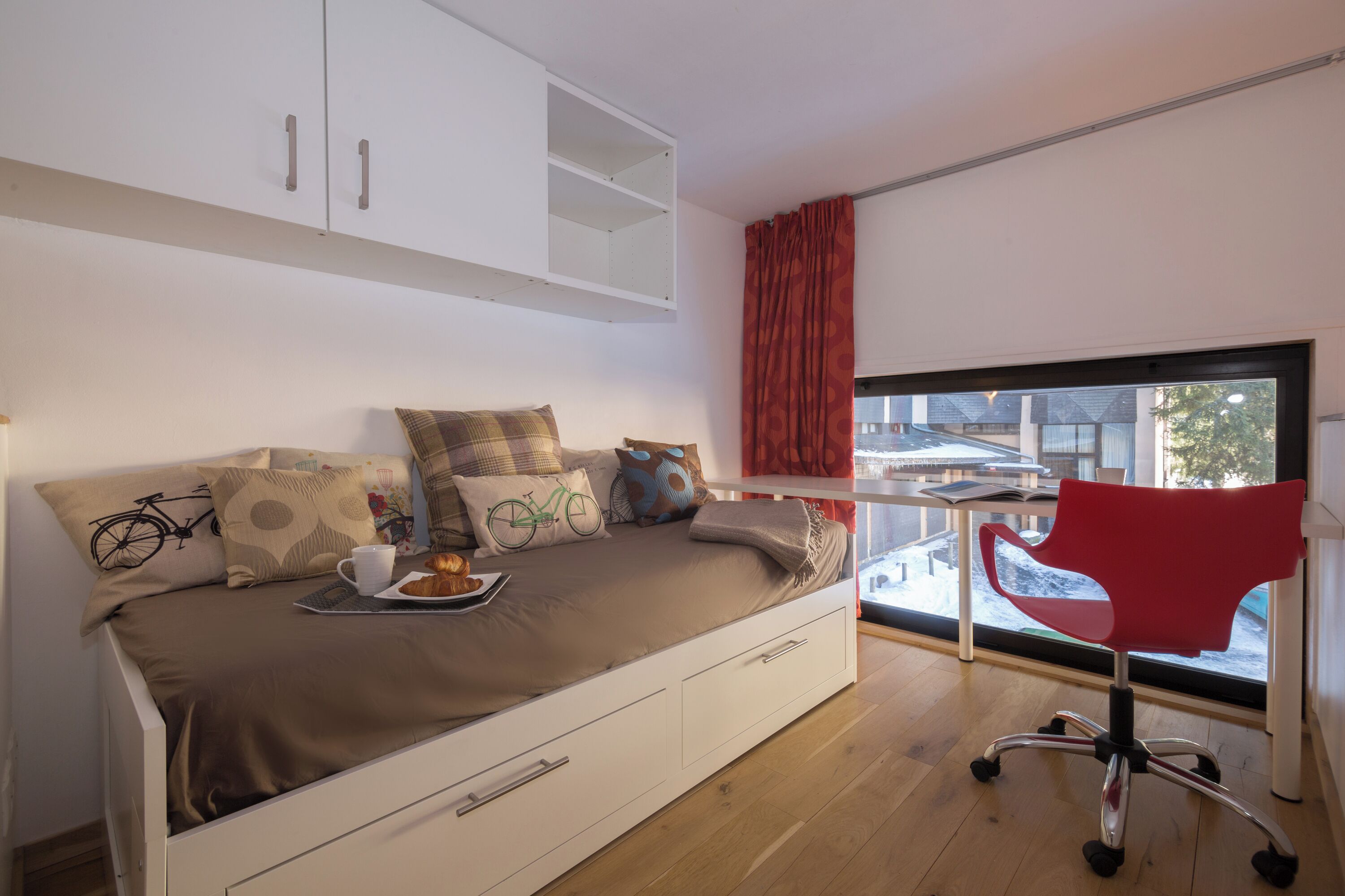 Une chambre moderne avec un lit, un bureau et une fenêtre.