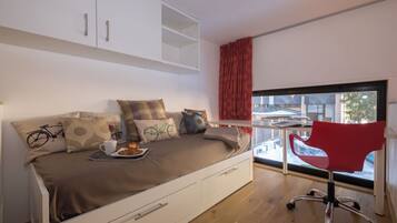 Une chambre moderne avec un lit, un bureau et une fenêtre.