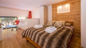 A bedroom with a wooden headboard, a fur throw, and two towels on the bed. - Grand Roc B22 260m from Slopes, View, Parking & WiFi, Argentière (Chamonix), France (Argentière (Chamonix))