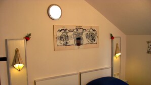 A bedroom with two beds, a ceiling light, and a wall-mounted artwork. - Sea view Apartment in Trogir near the beach (Trogir)