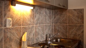 A modern kitchen with a stainless steel sink, a built-in oven, and a marble backsplash. - Sea view Apartment in Trogir near the beach (Trogir)