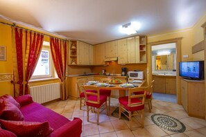 A compact living space with a dining area, kitchenette, and a television. - Smeraldo Ski in, Livigno, Italy (Livigno)