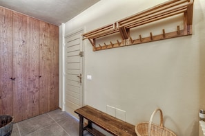A hallway with a wooden door, a bench, a wall-mounted coat rack, and a wicker basket. - Androsace 31 Walk to Ski Lifts + Pool & Mont-Blanc View in Argentière, Argentière (Chamonix), France (Argentière (Chamonix))