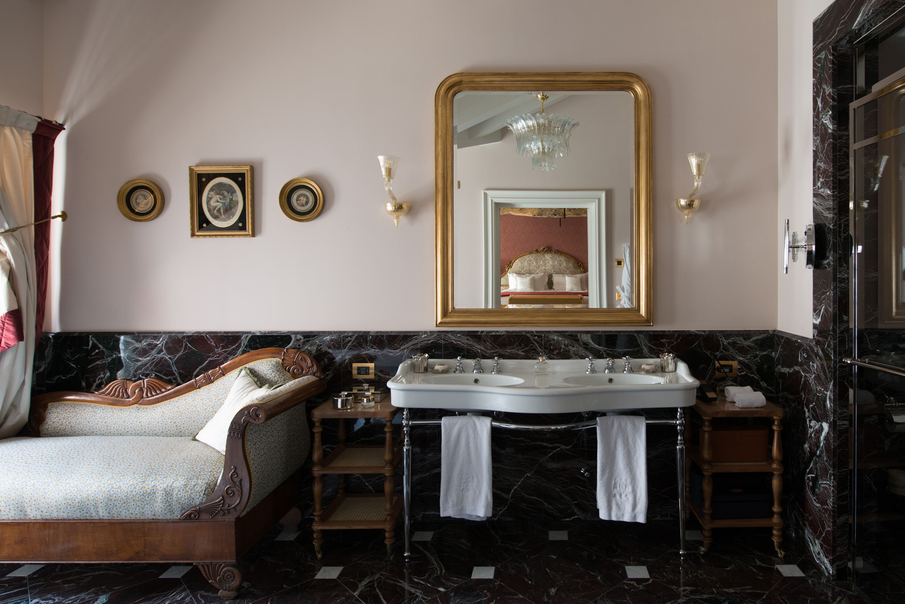 Un baño lujoso con un espejo grande, dos lavamanos y piso de mármol.