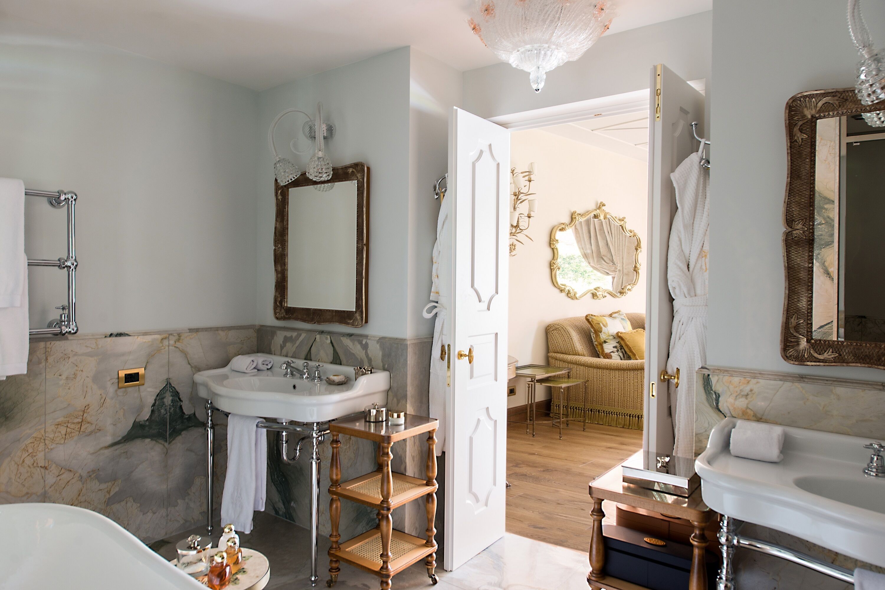 A bathroom with a freestanding bathtub, a large mirror, and a vanity with a sink.