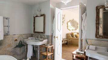 A bathroom with a freestanding bathtub, a large mirror, and a vanity with a sink.