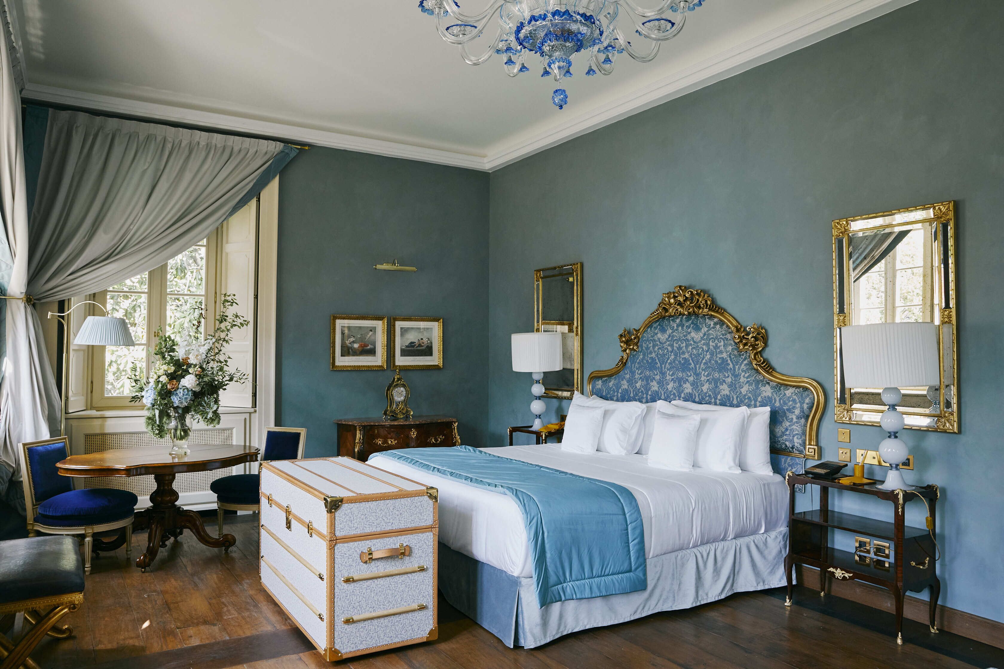 Ein Schlafzimmer mit einem großen Bett, einem Schminktisch, einem Schreibtisch und einem Stuhl.