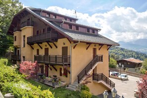 Un immeuble à deux étages doté de balcons, d’un escalier et d’un espace de stationnement.