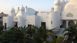 A white building with multiple domes and towers, surrounded by palm trees. - Incredible villa in urbanization with heated pool (Adeje)