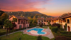 Un resort con piscina, ville e montagne sullo sfondo.