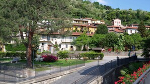 Una zona residenziale su una collina, con case, un sentiero in pietra e una ringhiera in metallo.