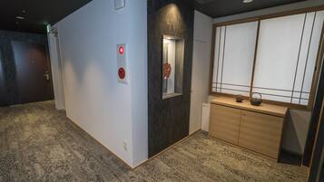 A hallway with a reception desk, a mirror, and a wooden cabinet.
