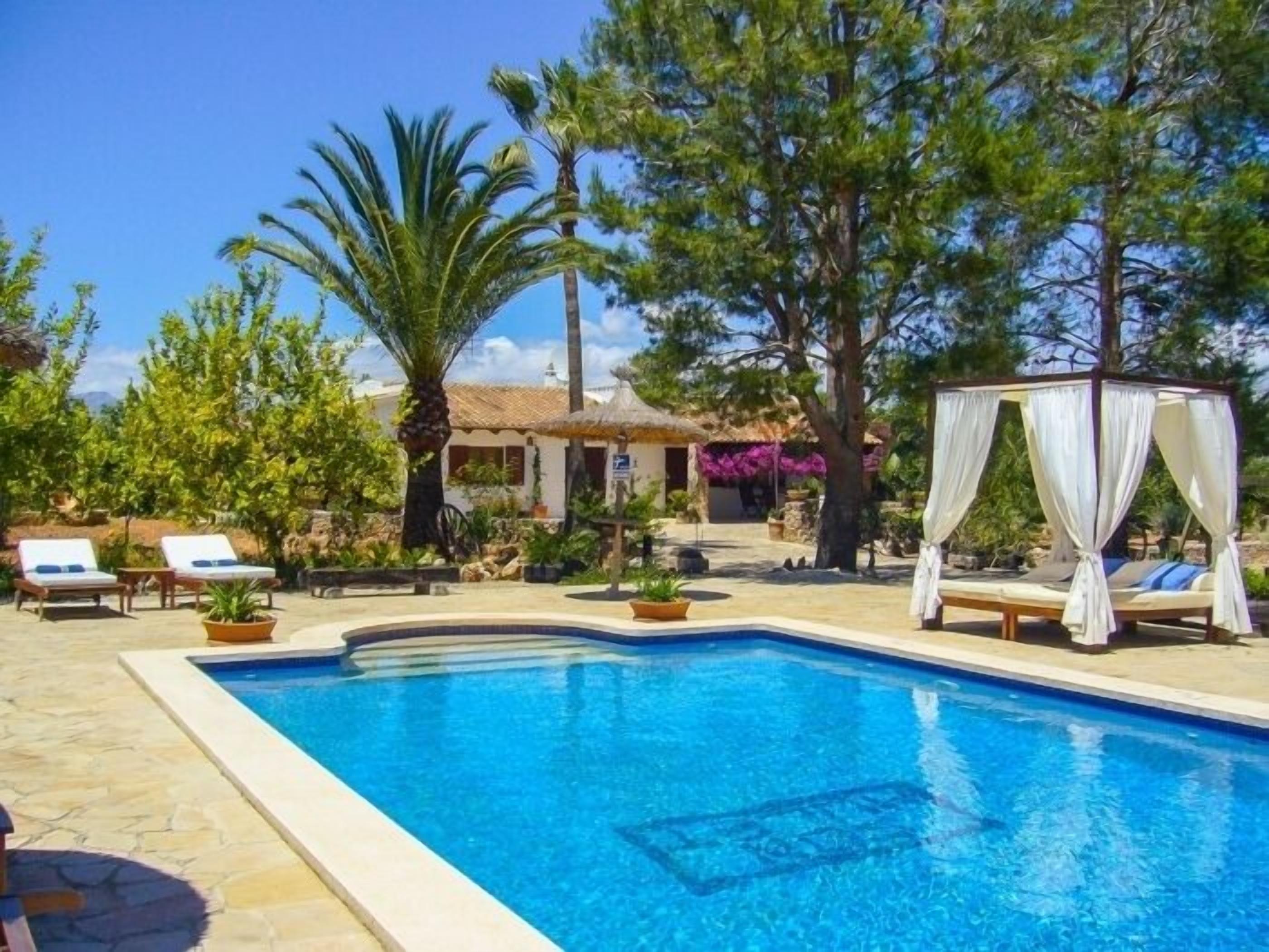 Ein Pool mit Liegestühlen und Sonnensegel.