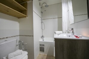 Une salle de bain avec des toilettes, une douche et un lavabo.
