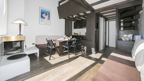 A modern kitchen with dark wooden beams, a dining area with a table and chairs, and a cozy seating area with a sofa. - Grand Roc B309 260m from Slopes, Mont-Blanc View, Parking & WiFi, Argentière (Chamonix), France (Argentière (Chamonix))
