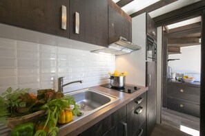 A modern kitchen with a stainless steel sink, a pot on the countertop, and wooden cabinets.