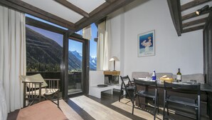 A modern room with a large window, a dining area, and a sofa. - Grand Roc B309 260m from Slopes, Mont-Blanc View, Parking & WiFi, Argentière (Chamonix), France (Argentière (Chamonix))