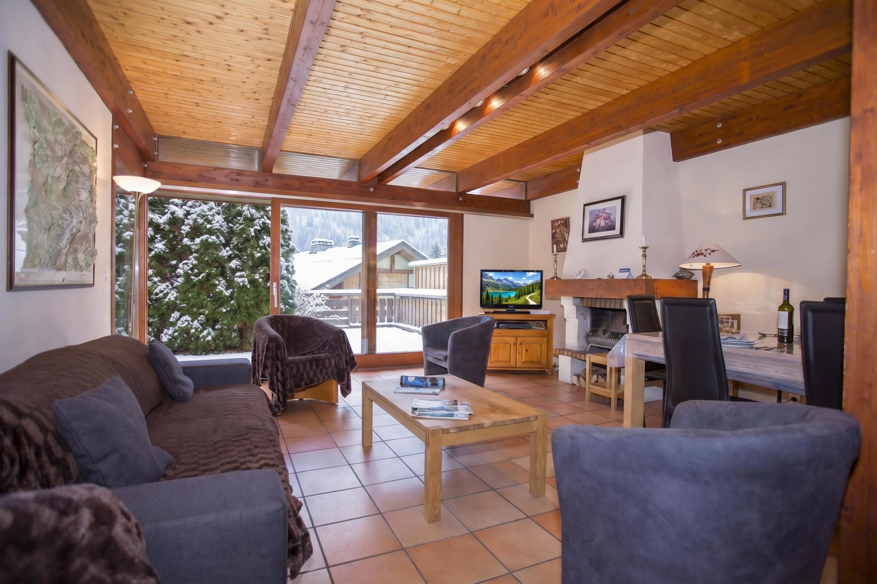 Een gezellige woonkamer met een bank, fauteuil en een televisie.