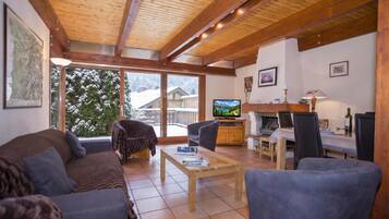 Een gezellige woonkamer met een bank, fauteuil en een televisie.