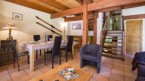 Ein Essbereich mit Holztisch und -stühlen, einer Holztreppe und einer Holztür.