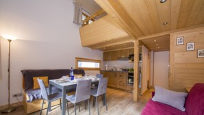 A cozy living room with a dining area, wooden ceiling, and a kitchenette. - Grand Roc B121 260m from Slopes, View & Parking, Argentière (Chamonix), France (Argentière (Chamonix))