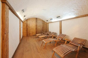 A room with wooden walls and ceiling, a sloped roof, and several wooden chairs arranged for seating. - Stella Alpina, Livigno, Italy (Livigno)