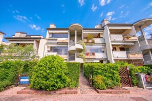 A multi-story residential building with balconies, a central courtyard, and a well-maintained garden. - Residenza Verde - 3 Pools & Garage, Desenzano Del Garda, Italy (Desenzano Del Garda)