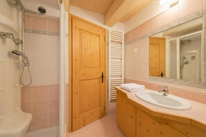 Une salle de bain avec une douche, un lavabo et un miroir.