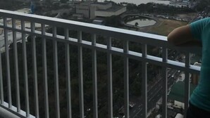 Un immeuble de grande hauteur offrant une vue sur un plan d’eau, un pont et un stade.