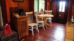 A wooden interior with a wooden table and chairs, a coffee machine, and a sign that reads "WELCOME".
