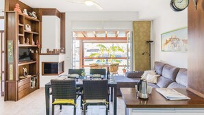 Amplia sala de estar con una mesa de comedor, sillas, un sofá y una estantería.