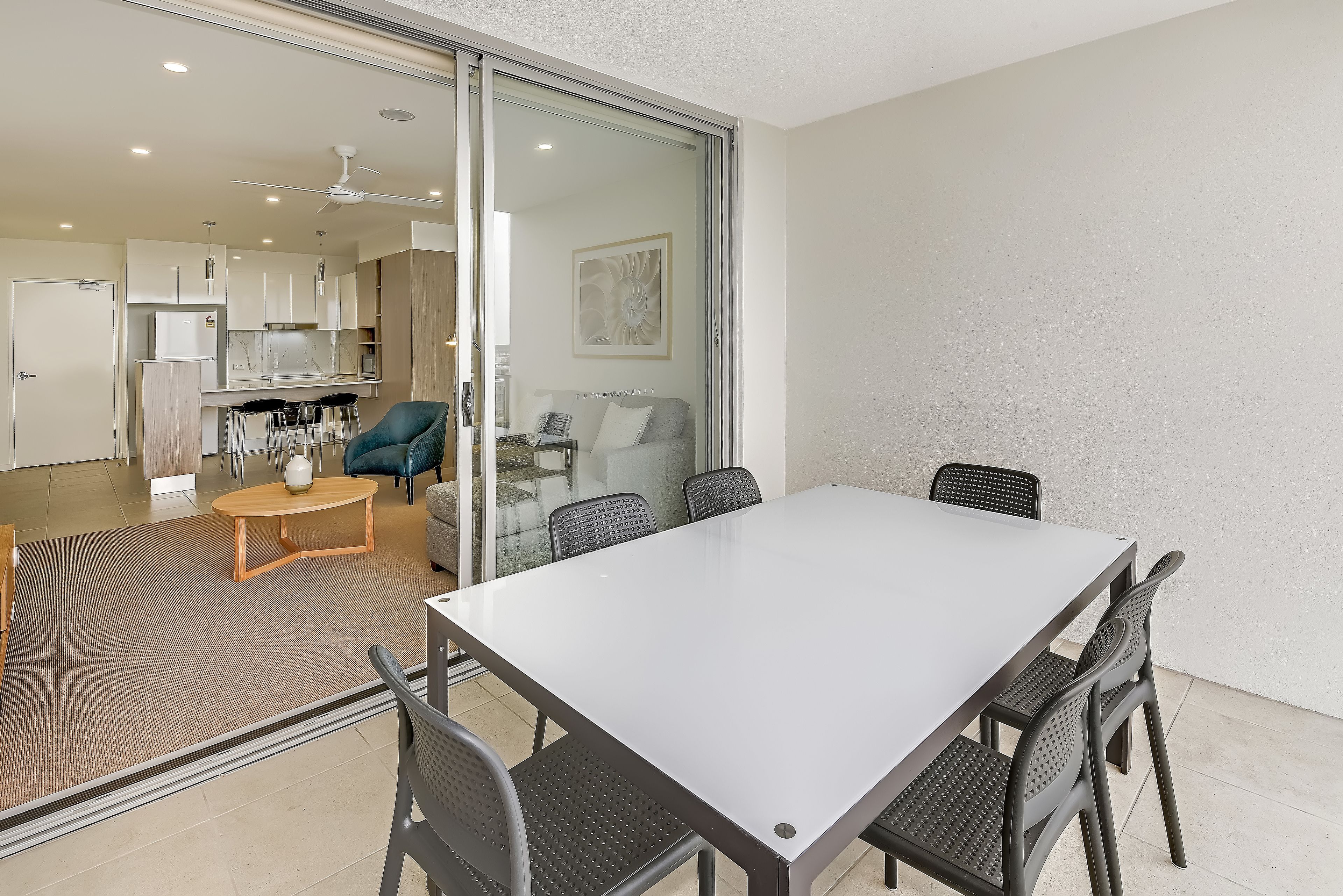 A modern kitchen with a glass door leading to a dining area.